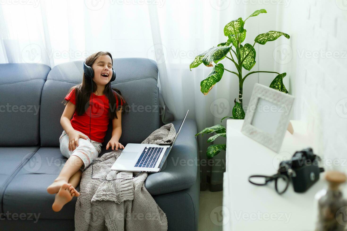 Remote lessons. The child smiles happily and gets knowledge remotely. Little girl study online learning from home with laptop. Online school. photo