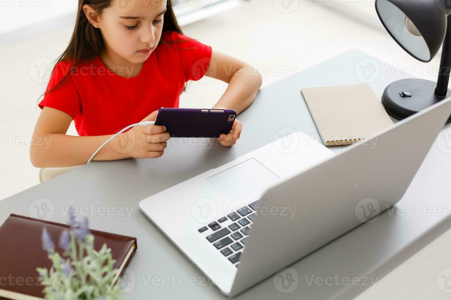 education, school, technology and internet concept - little student girl with smartphone at home photo