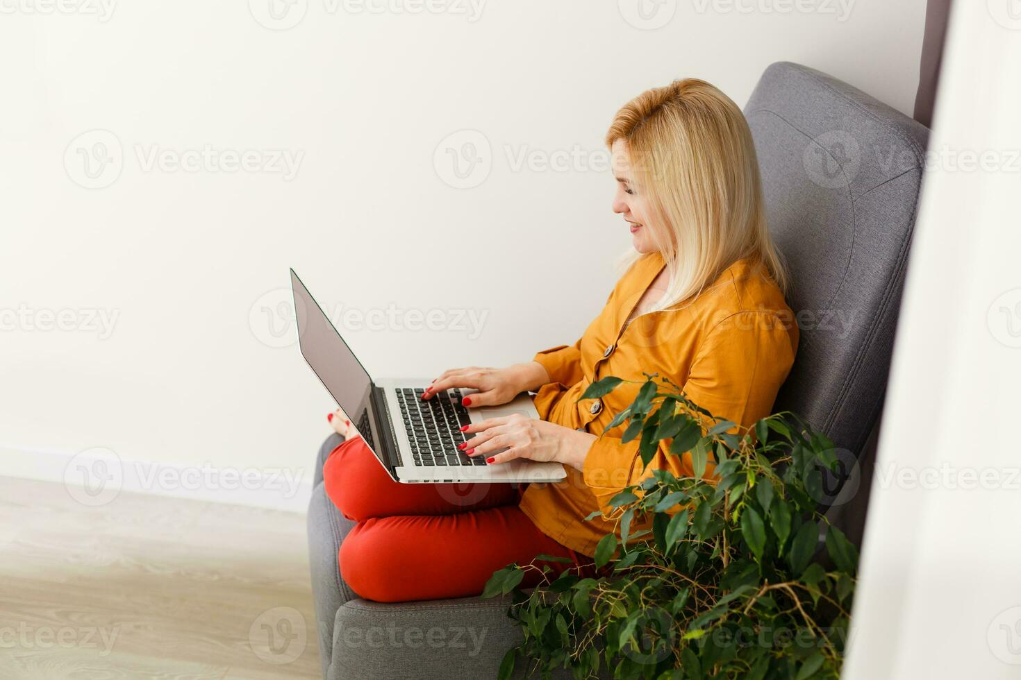 young beautiful smiling woman prints on the laptop - indoors photo