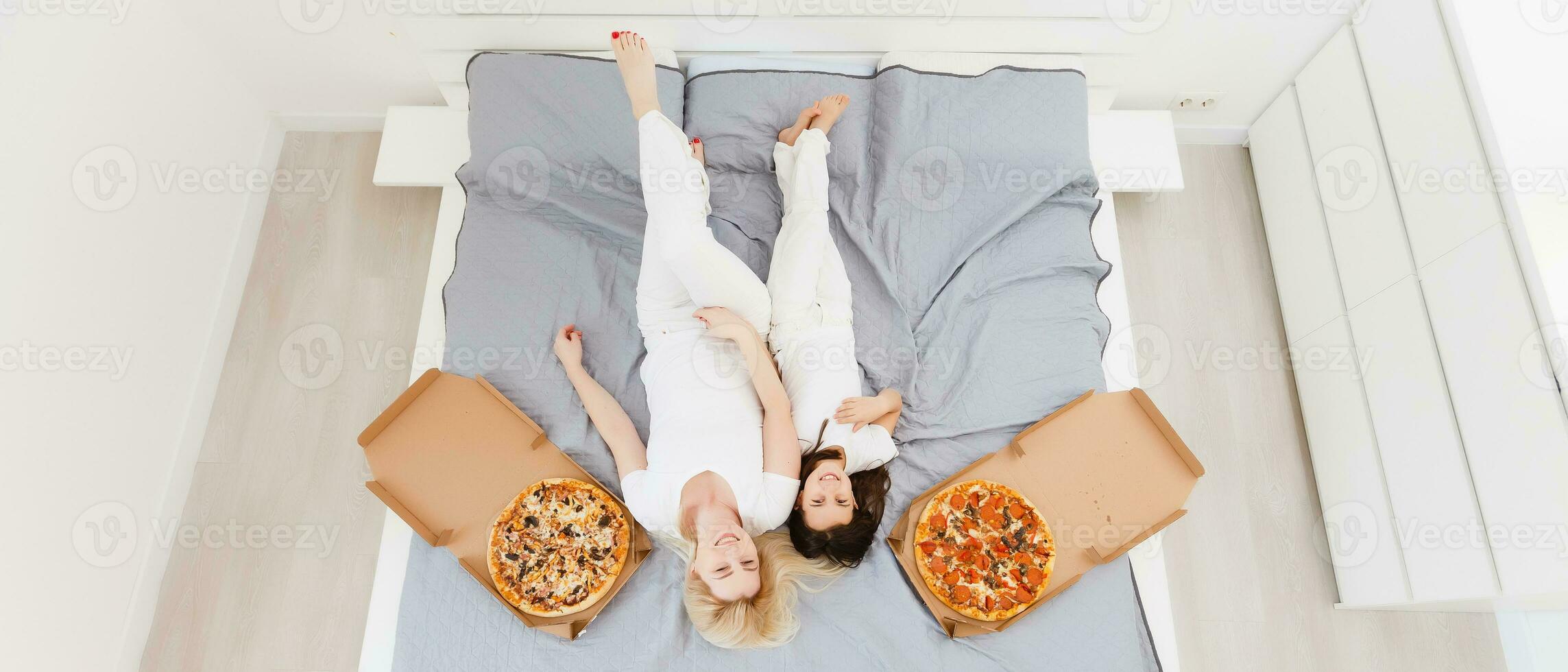 Mother and daughter eating pizza. relaxing at home photo