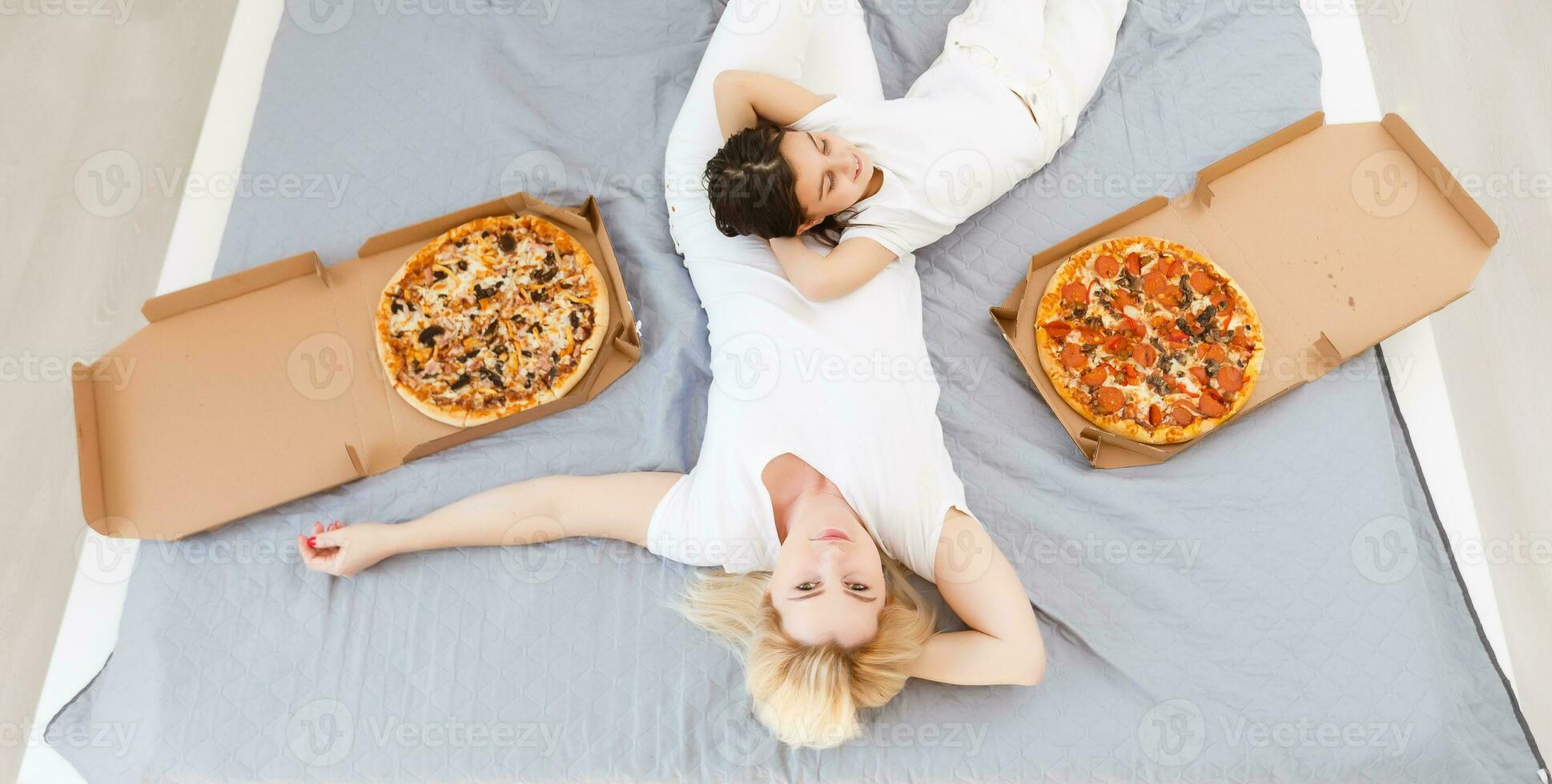 Mother and daughter eating pizza. relaxing at home photo