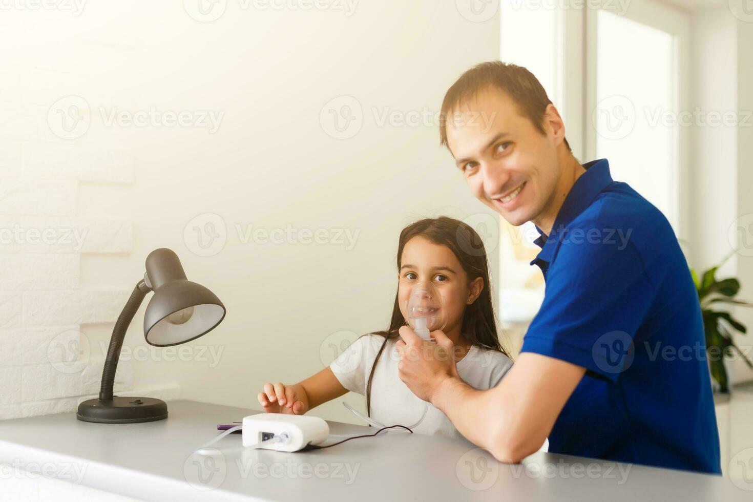Little toddler girl making inhalation with nebulizer at home. Father helping and holding the device. Child having flu, cough and bronchitis. asthma inhaler inhalation steam sick concept photo