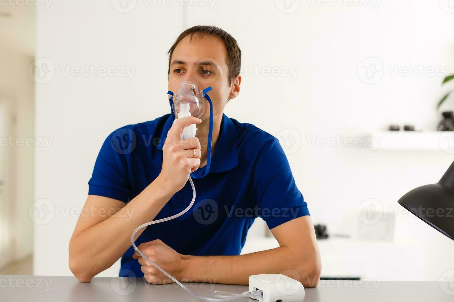 retrato de joven hombre inhalando mediante inhalador máscara foto
