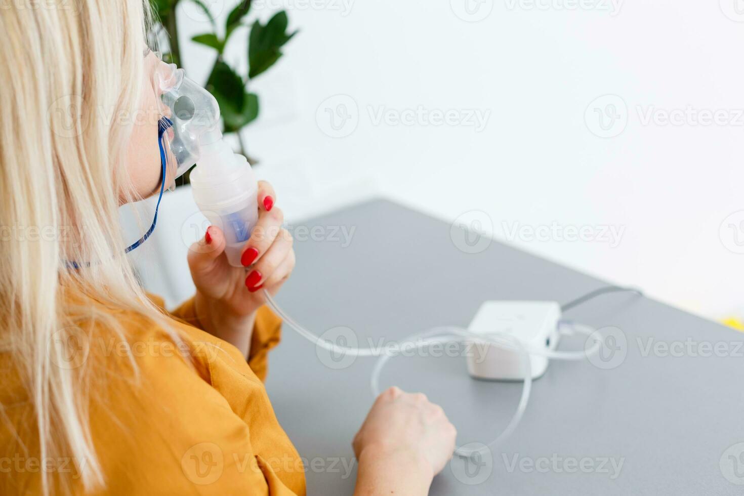 Portrait of adult woman using steam vapor inhaler nebulizer doing aerosol inhalation medicine treatment at home or hospital flu and asthma bronchitis virus healing photo