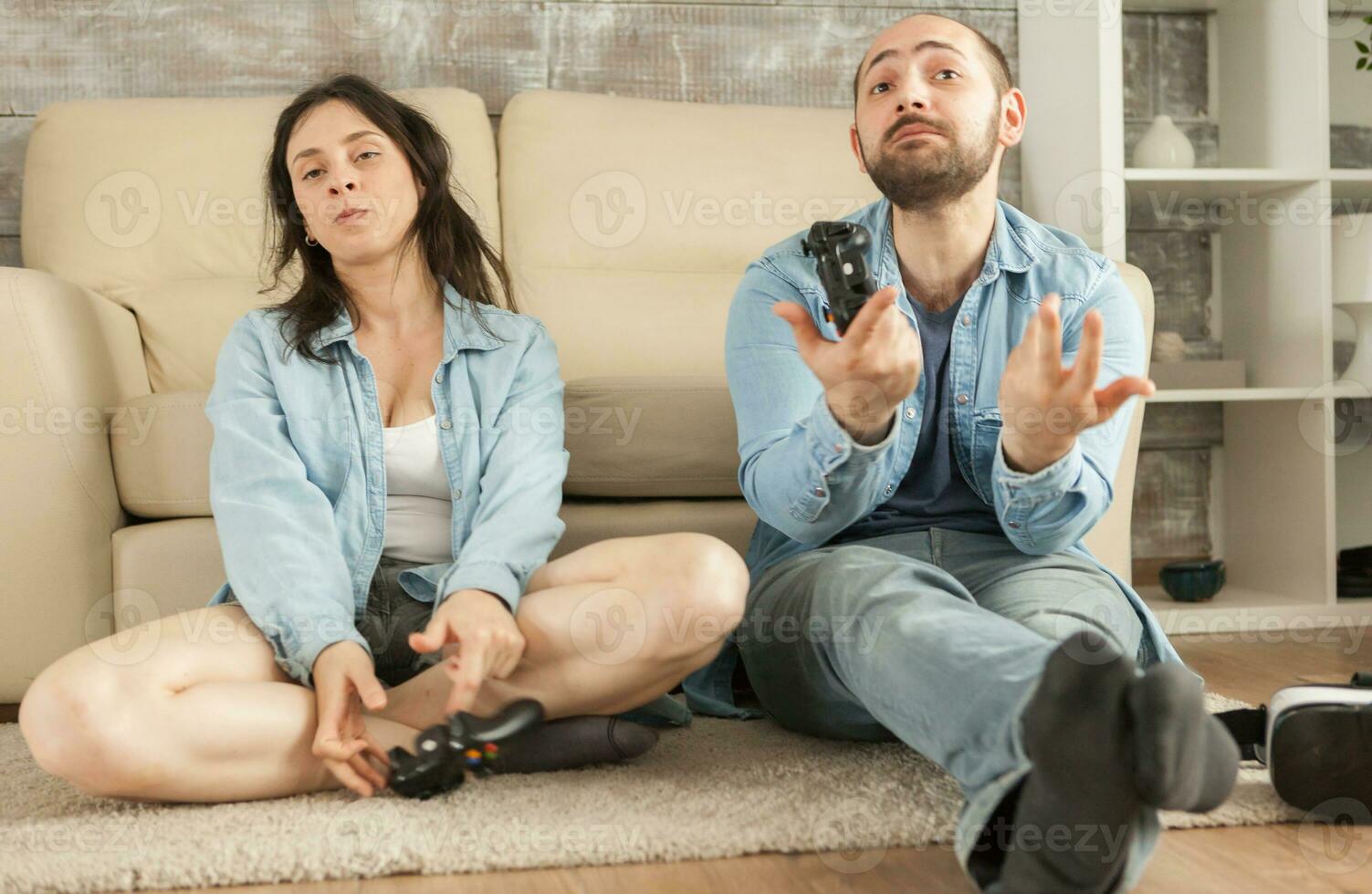 Couple losing at online video games using wireless controllers. photo