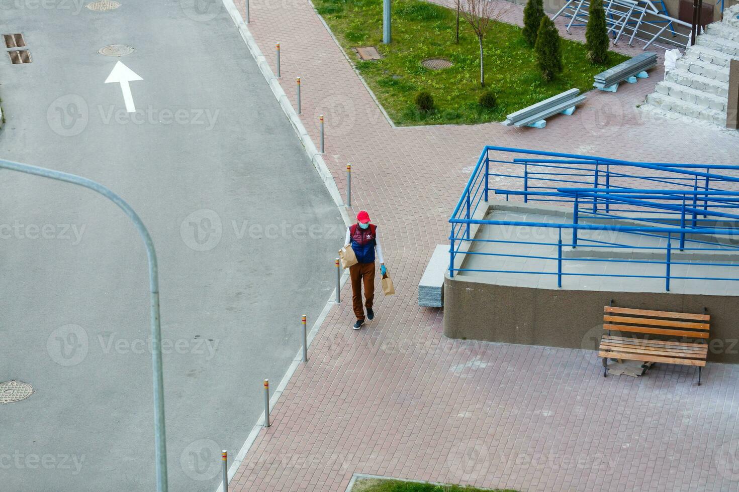 food delivery man on empty street producer of quarantine photo