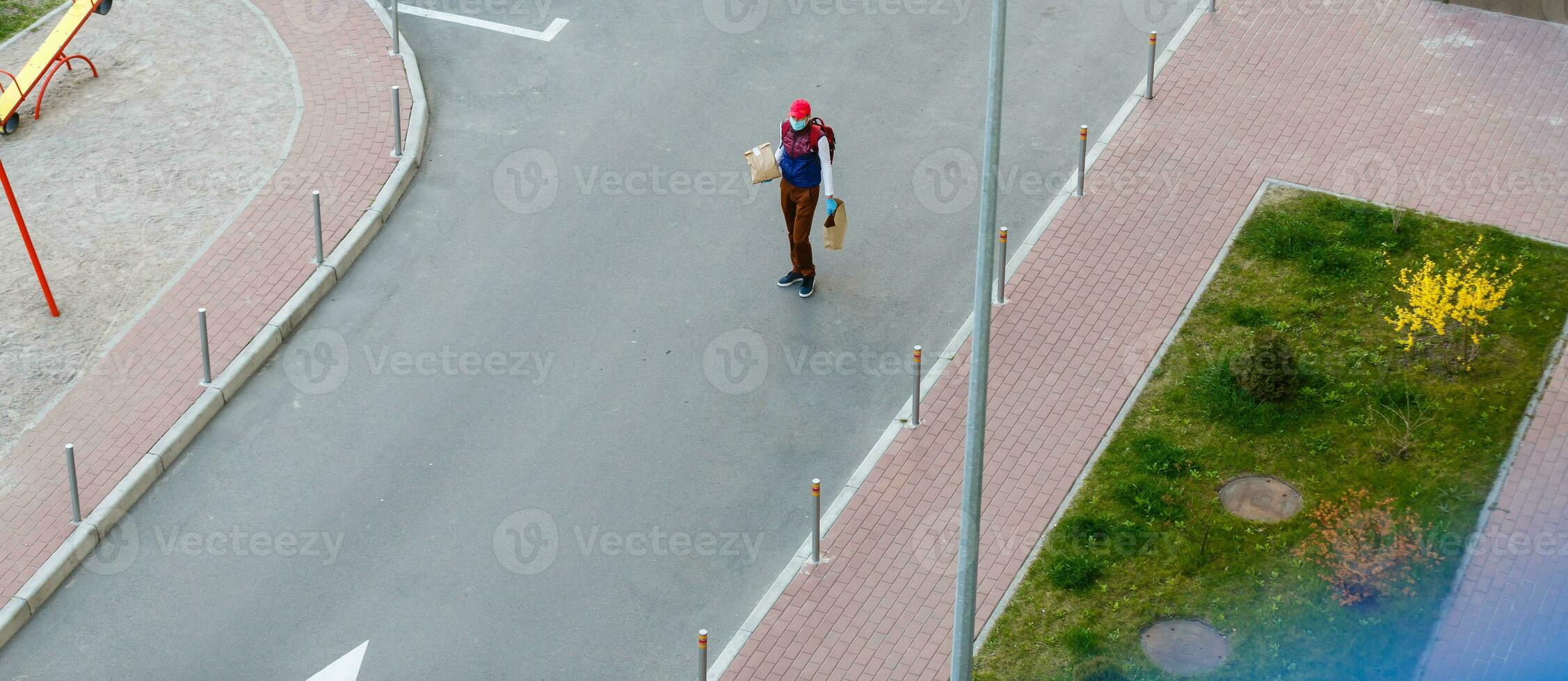 food delivery man on empty street producer of quarantine photo