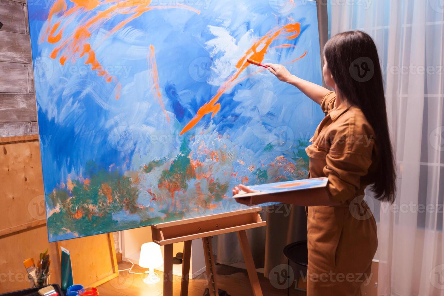 Artist holding paint palette in art workshop. Painting on large canvas. Modern artwork paint on canvas, creative, contemporary and successful fine art artist drawing masterpiece photo