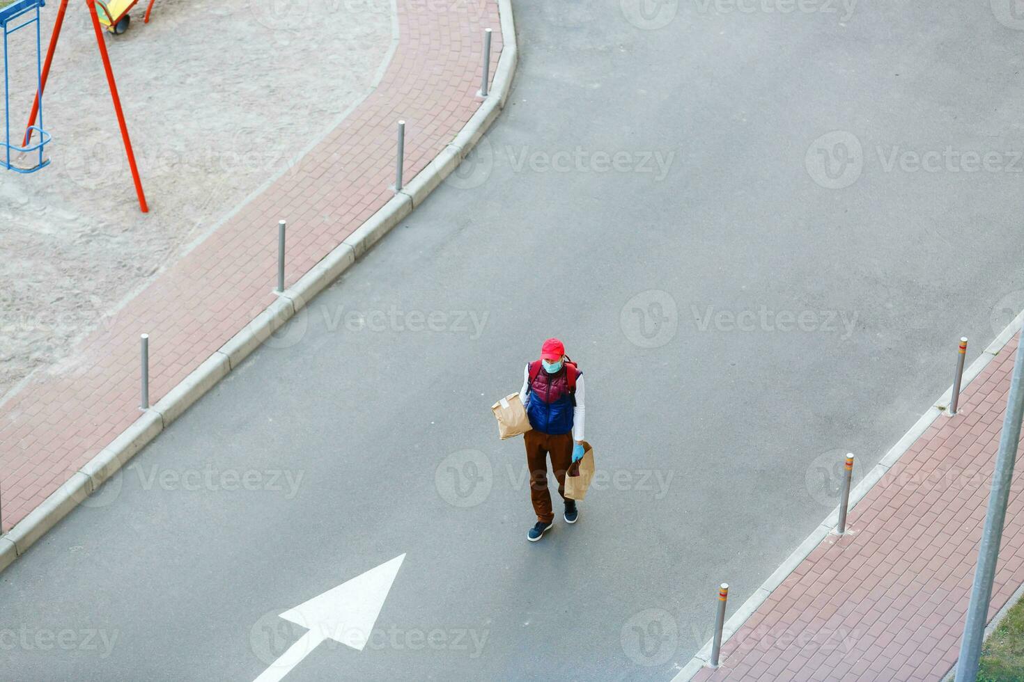 food delivery man on empty street producer of quarantine photo