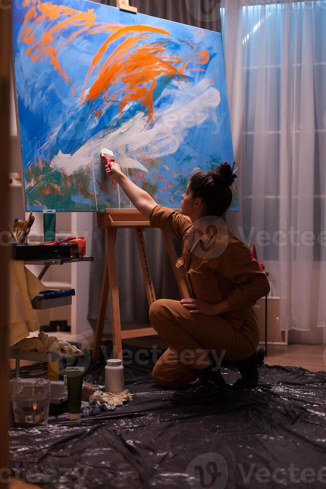 Famous woman artist working on impressionism painting in art workshop. Modern artwork paint on canvas, creative, contemporary and successful fine art artist drawing masterpiece photo