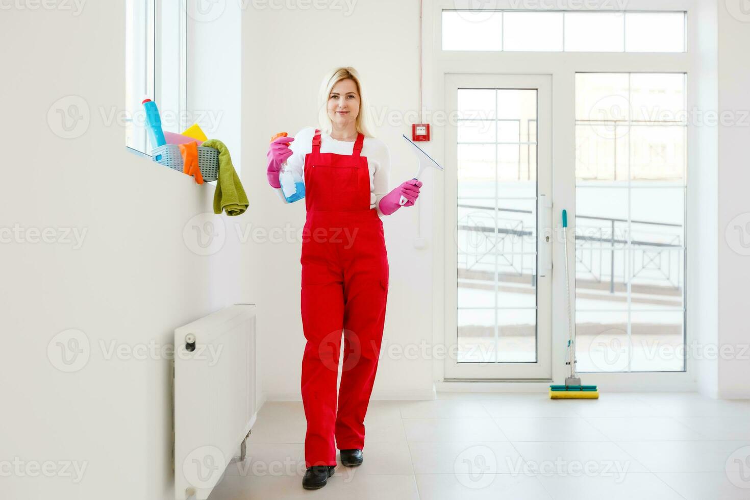 Woman cleaning windows at home with detergents cleaner photo