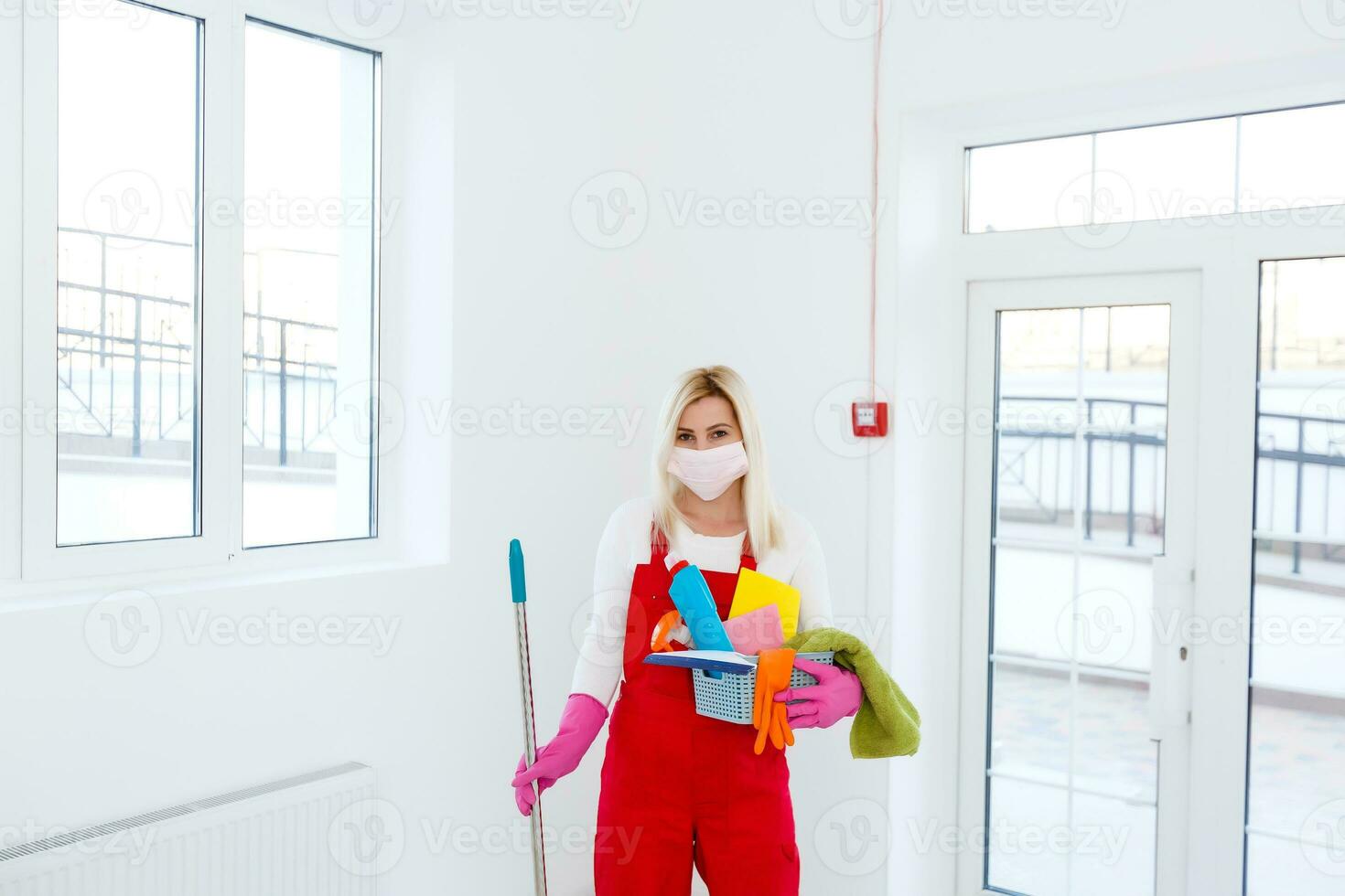 Coronavirus. woman with face mask cleaning and disinfecting her house during coronavirus epidemic. Prevention of COVID-19 infection. Stop coronavirus from spreading. photo