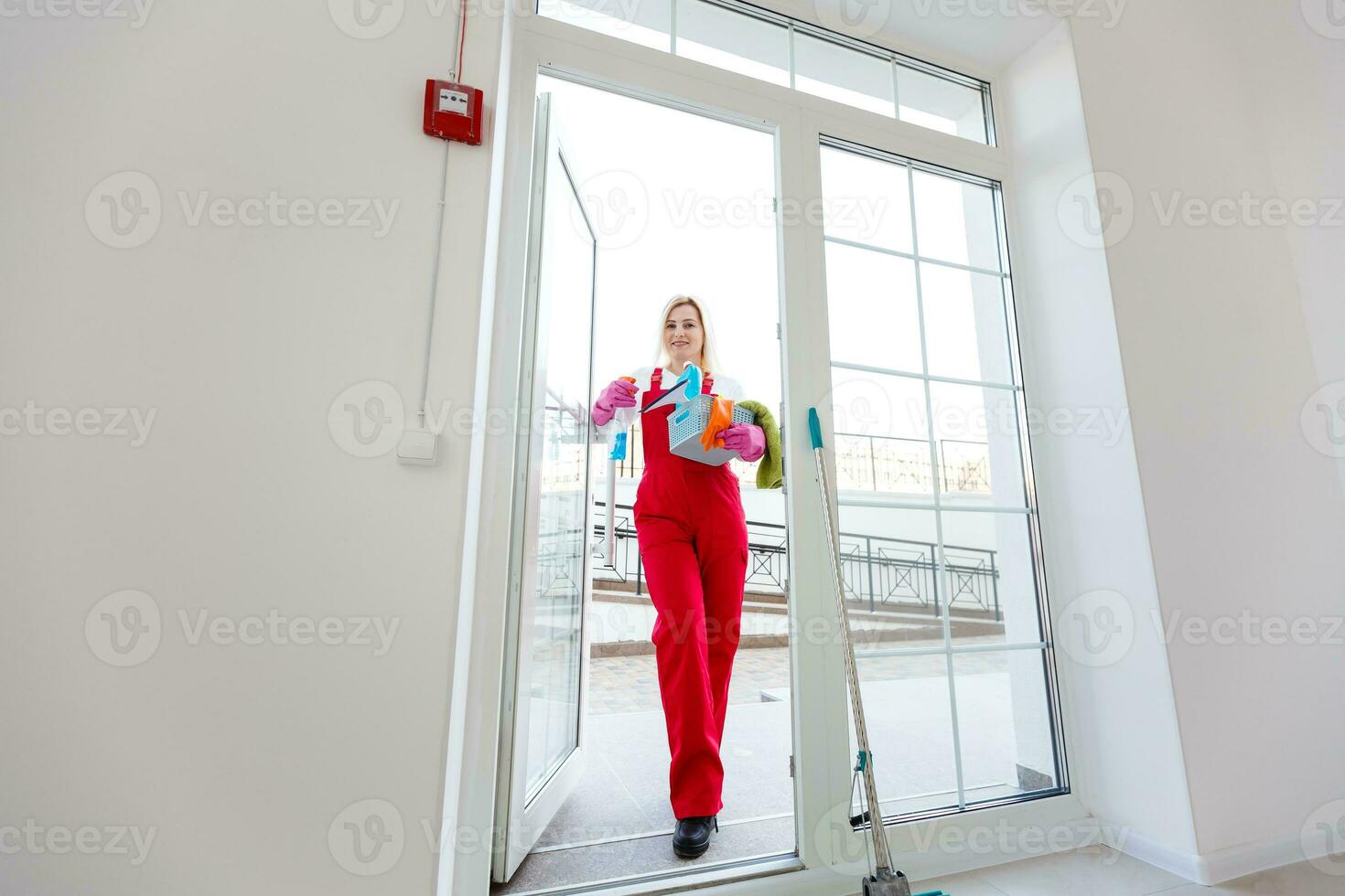 Beautiful young woman makes cleaning the house. Girl rubs dust. photo