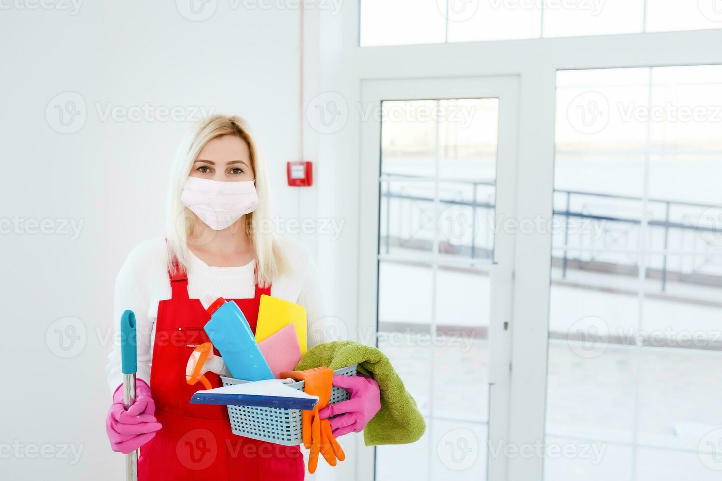 Coronavirus. woman with face mask cleaning and disinfecting her house during coronavirus epidemic. Prevention of COVID-19 infection. Stop coronavirus from spreading. photo