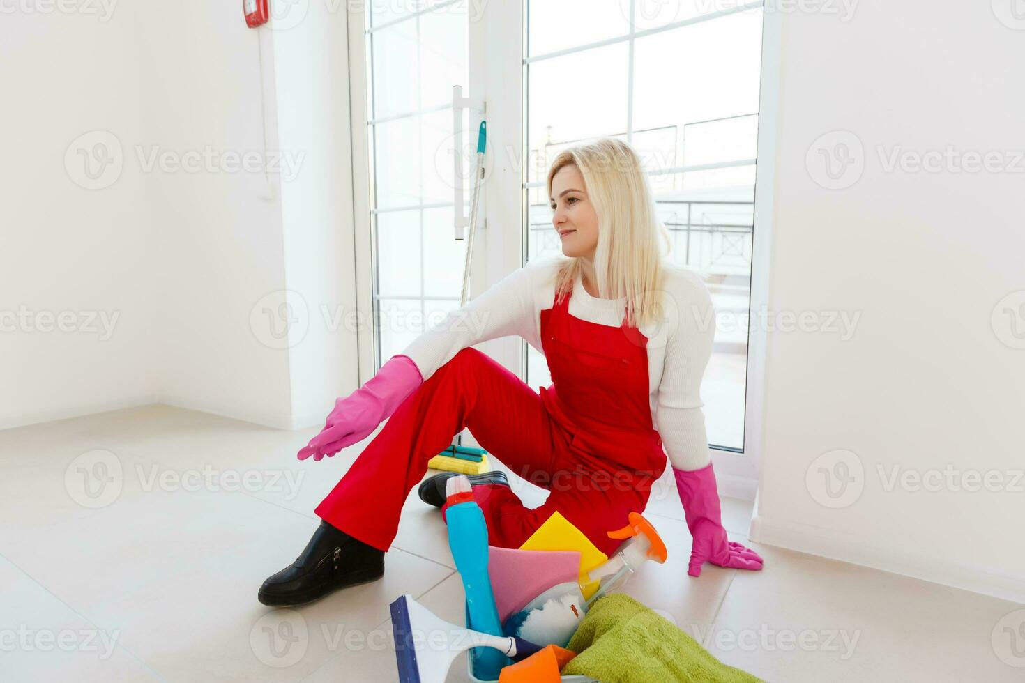 Beautiful young woman makes cleaning the house. Girl rubs dust. photo