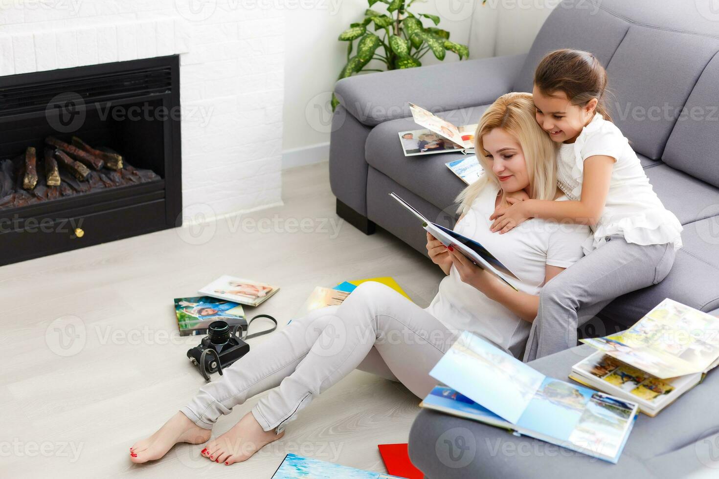 mother and daughter enjoying photo album in livingroom