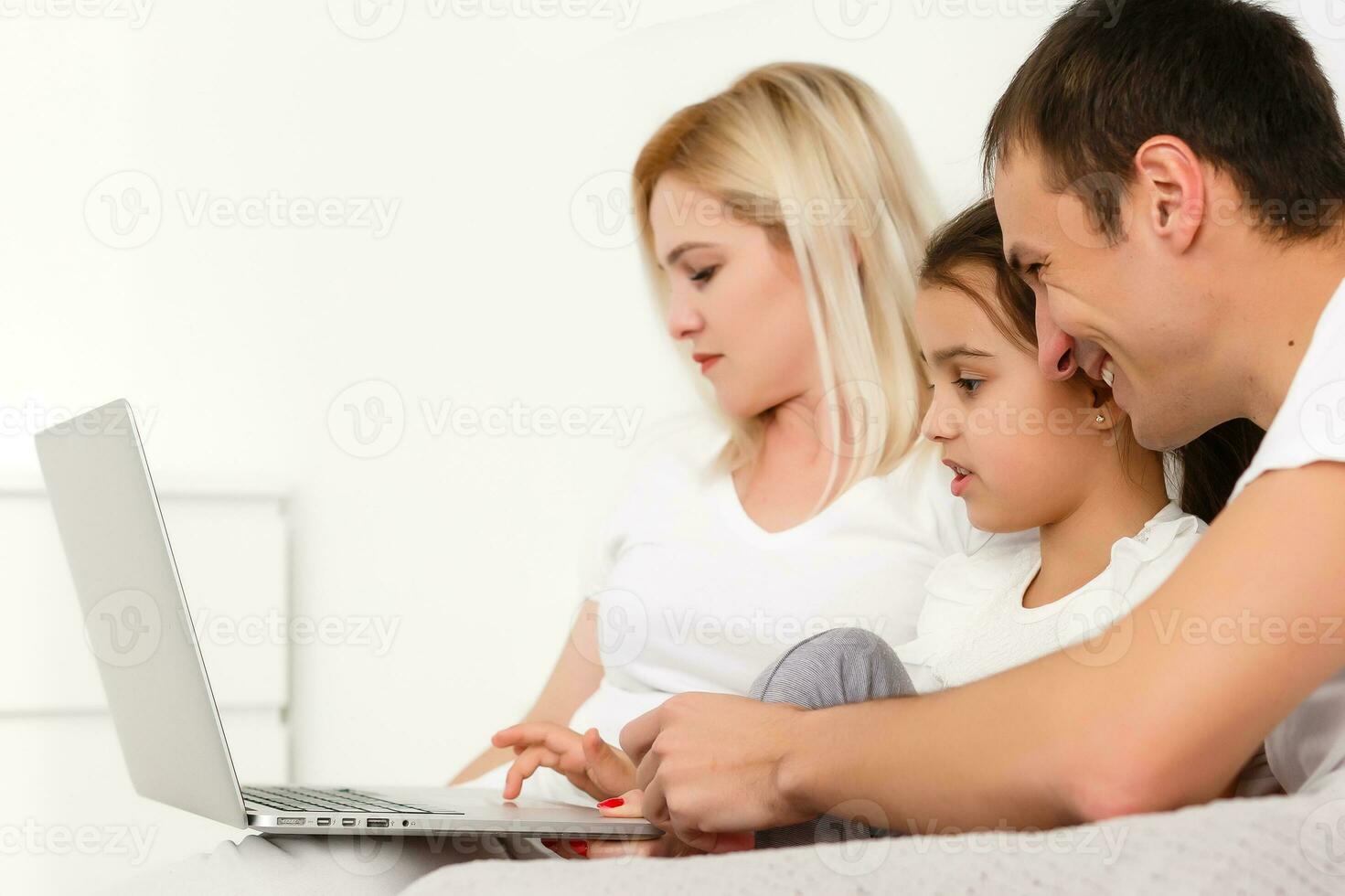 Animated family buying online lying down on bed at home photo