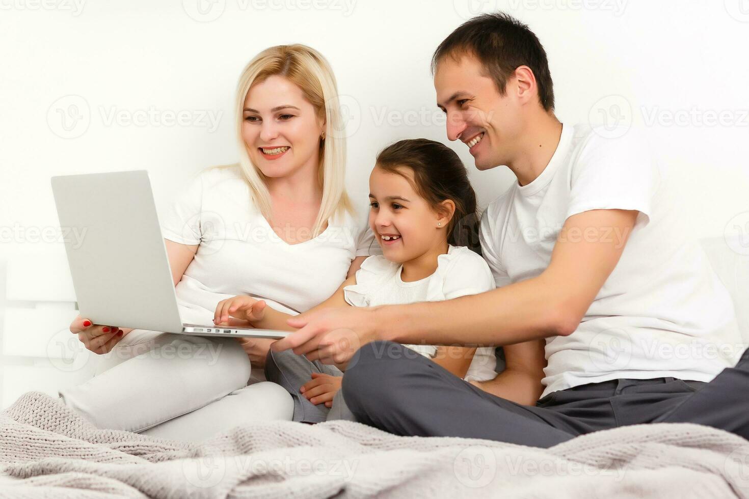 Animated family buying online lying down on bed at home photo