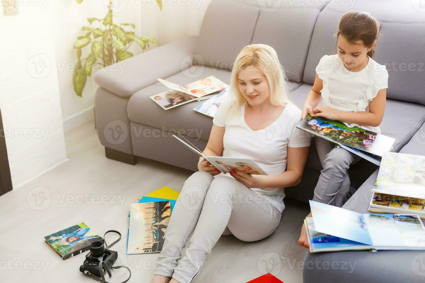 mother and daughter enjoying photo album in livingroom