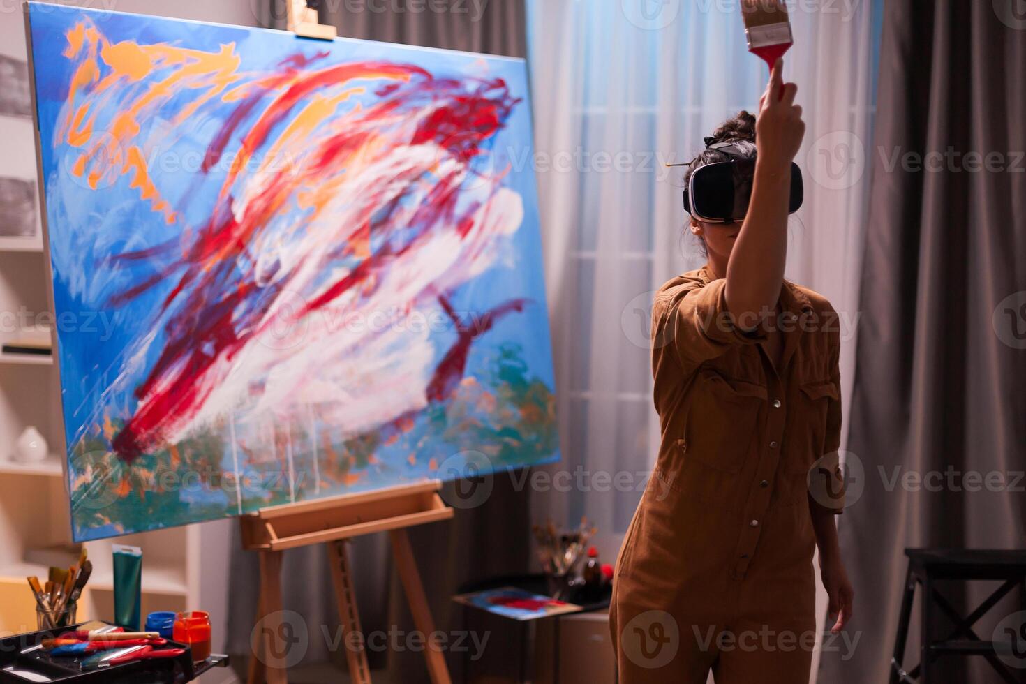 Talented painter with vr headset painting a masterpiece on canvas in art studio. Modern artwork paint on canvas, creative, contemporary and successful fine art artist drawing masterpiece photo