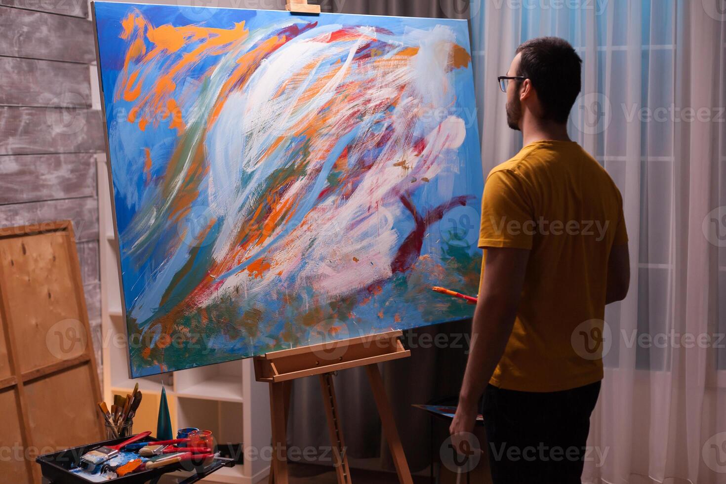 Successful artist in front of masterpiece oil painting in art workshop. Modern artwork paint on canvas, creative, contemporary and successful fine art artist drawing masterpiece photo