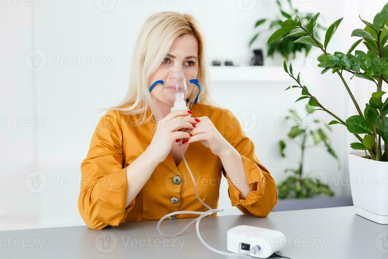 Portrait of adult woman using steam vapor inhaler nebulizer doing aerosol inhalation medicine treatment at home or hospital flu and asthma bronchitis virus healing photo