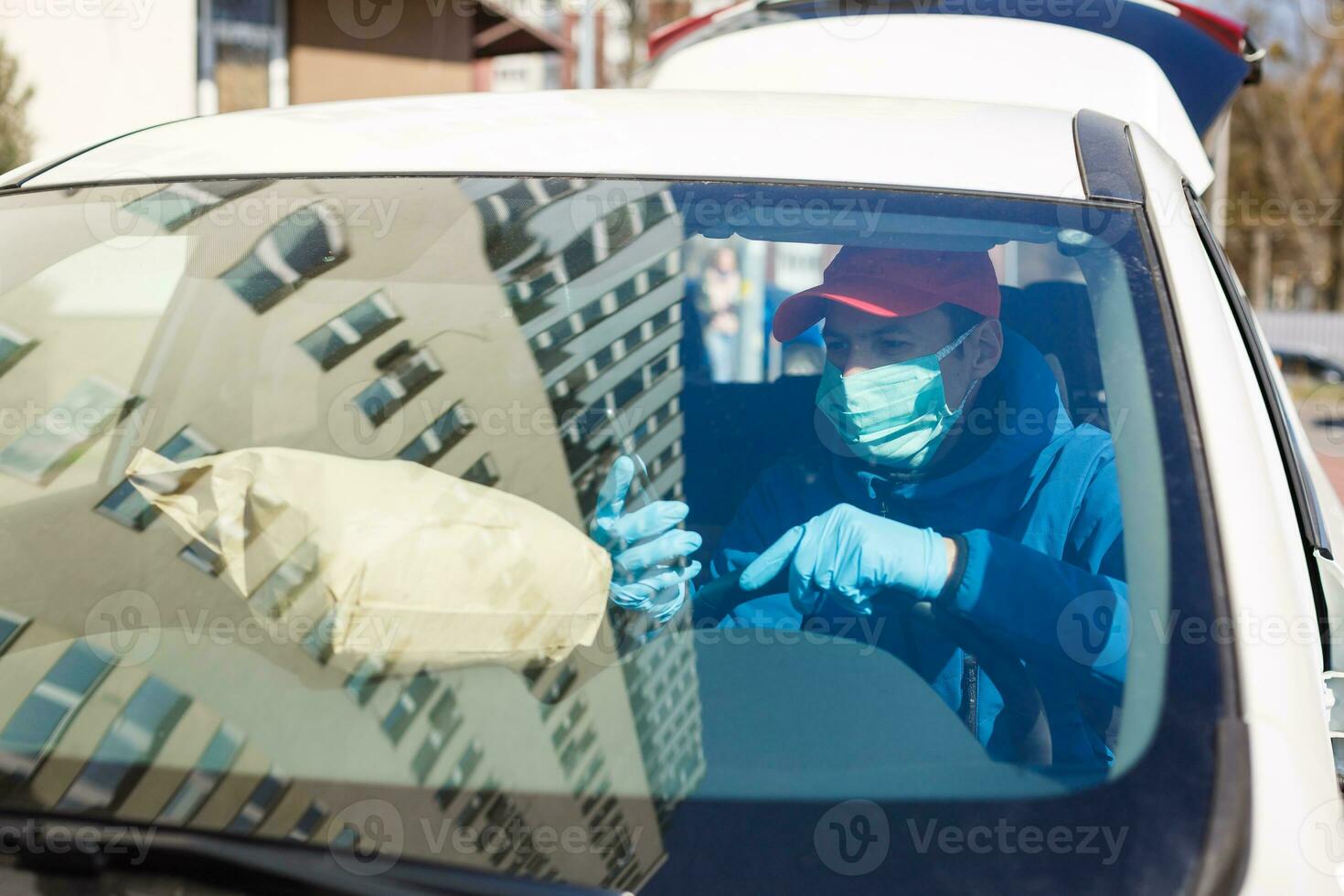 Courier in protective mask and medical gloves delivers takeaway food. Delivery service under quarantine, disease outbreak, coronavirus covid-19 pandemic conditions. photo