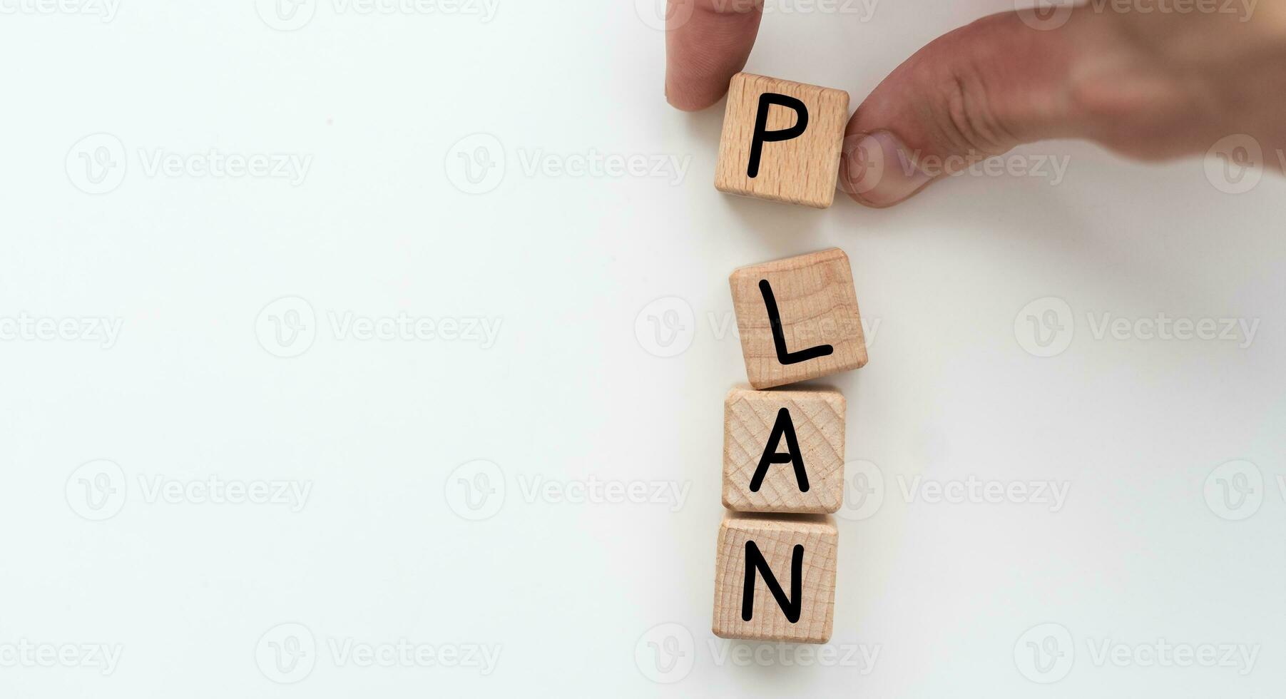 Plan concept. Hand holding a Wooden block with text on table. Copy space photo