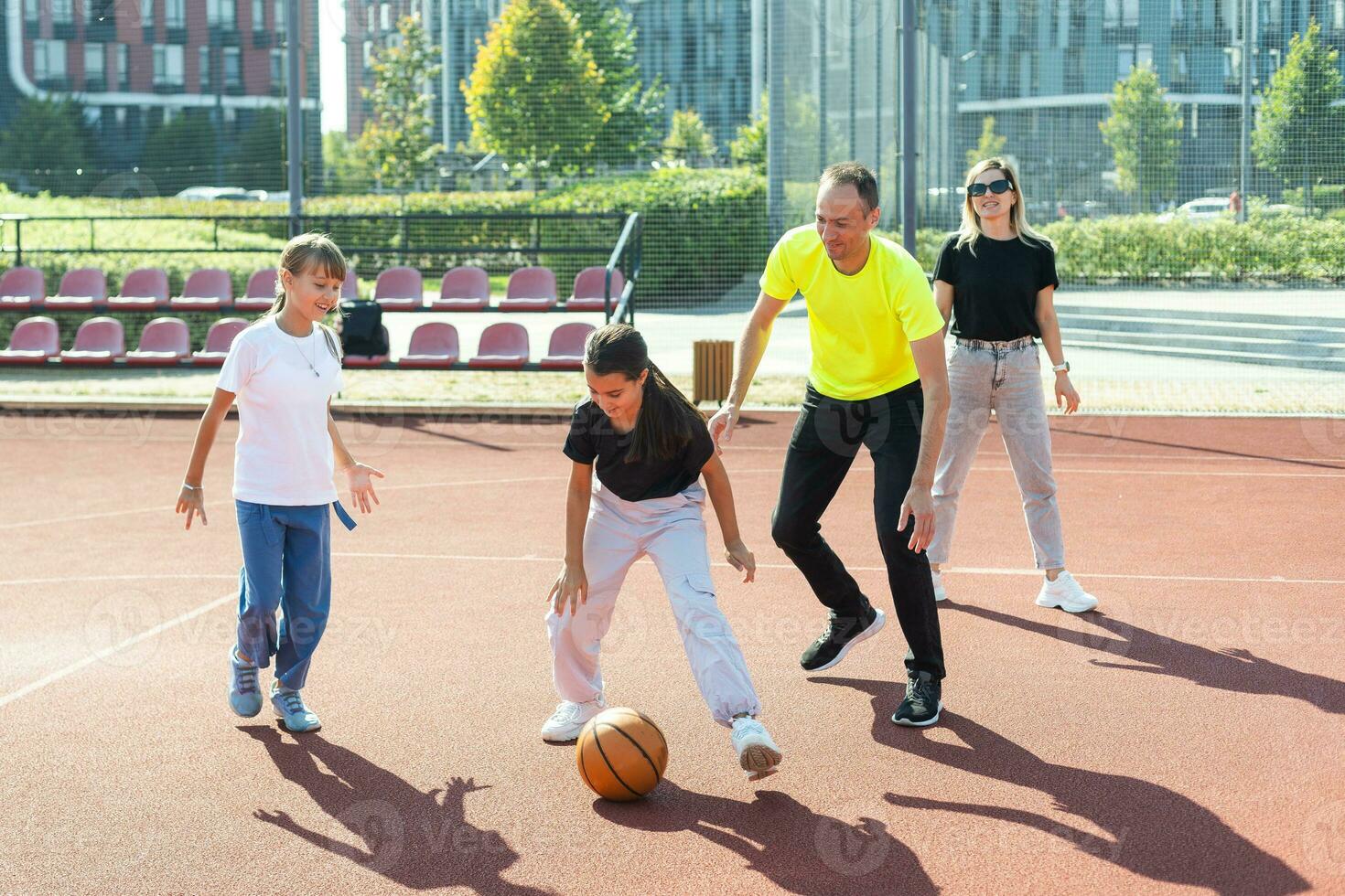 family playing basketball on court photo