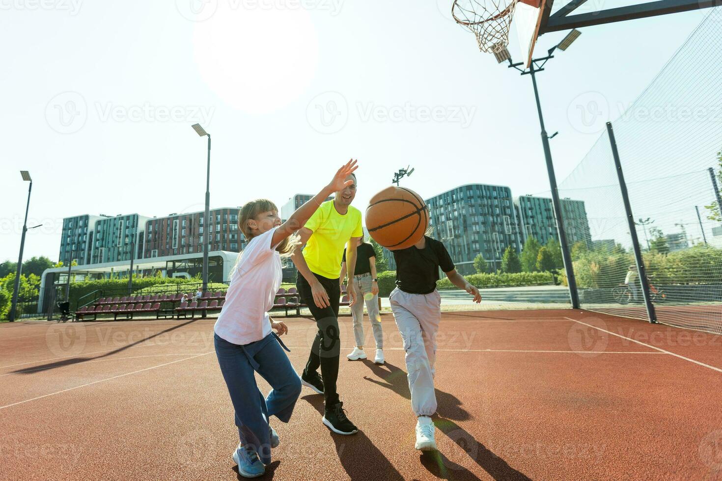 family playing basketball on court photo