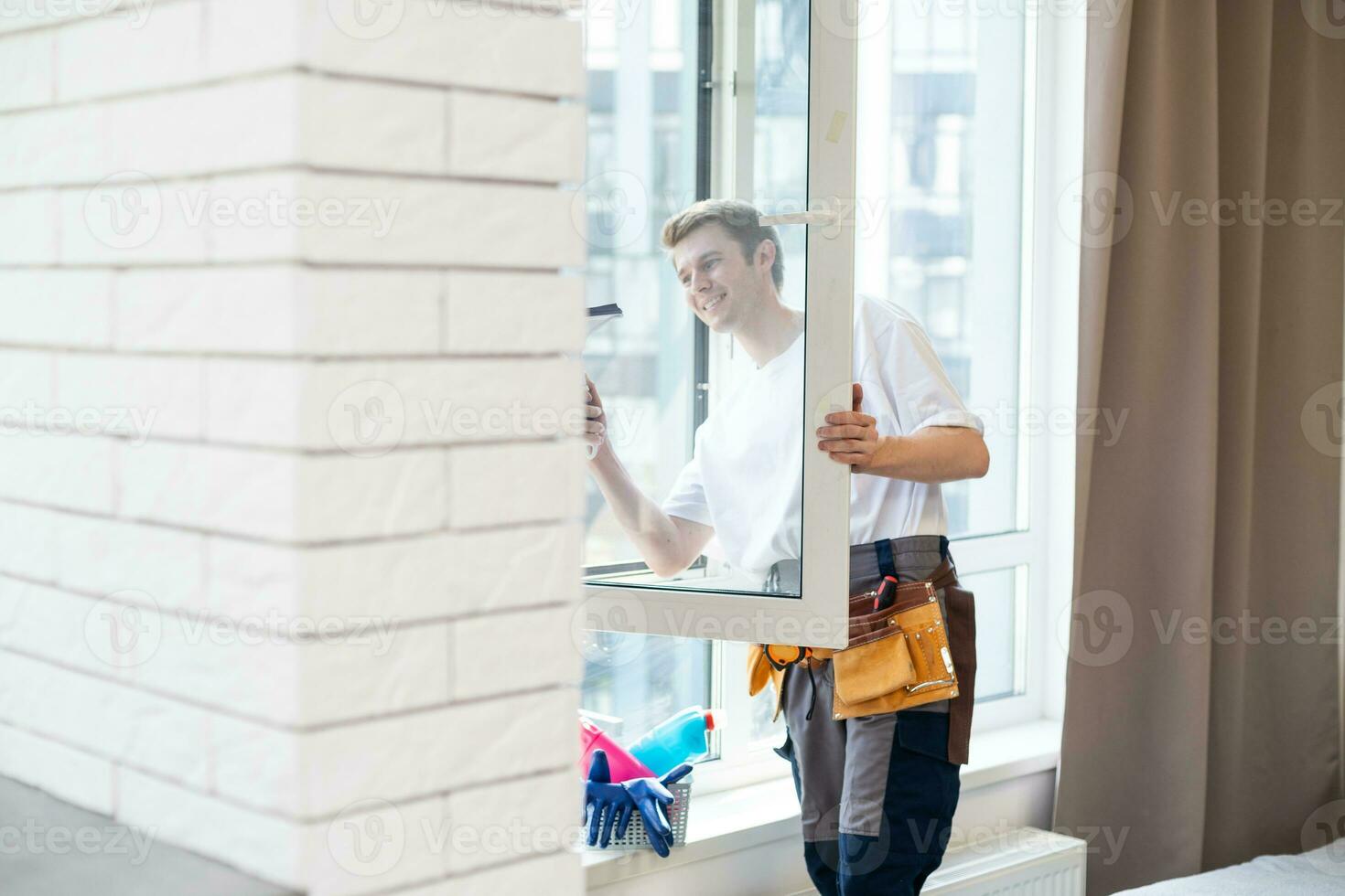 young man cleaning windows in the house photo