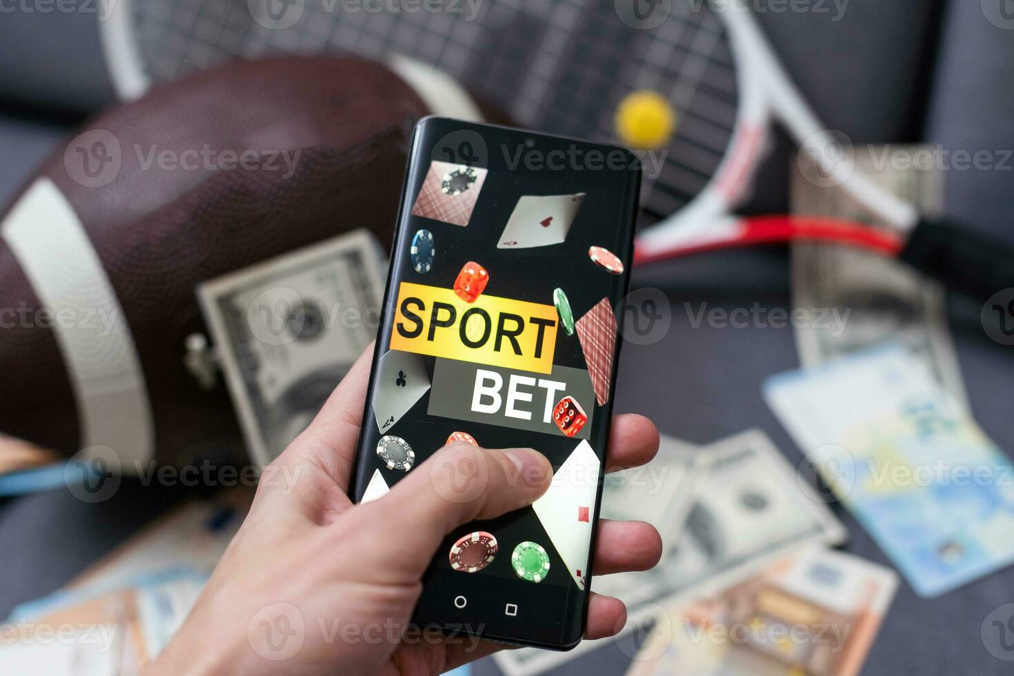 Sports betting website in a mobile phone screen, ball, money photo