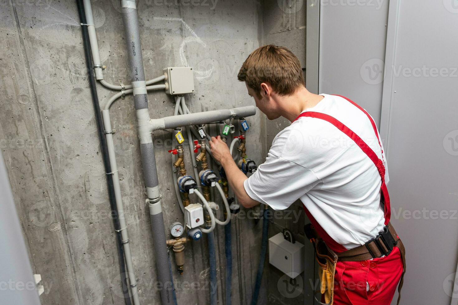 maintenance technician checking pressure meters for house heating system. photo