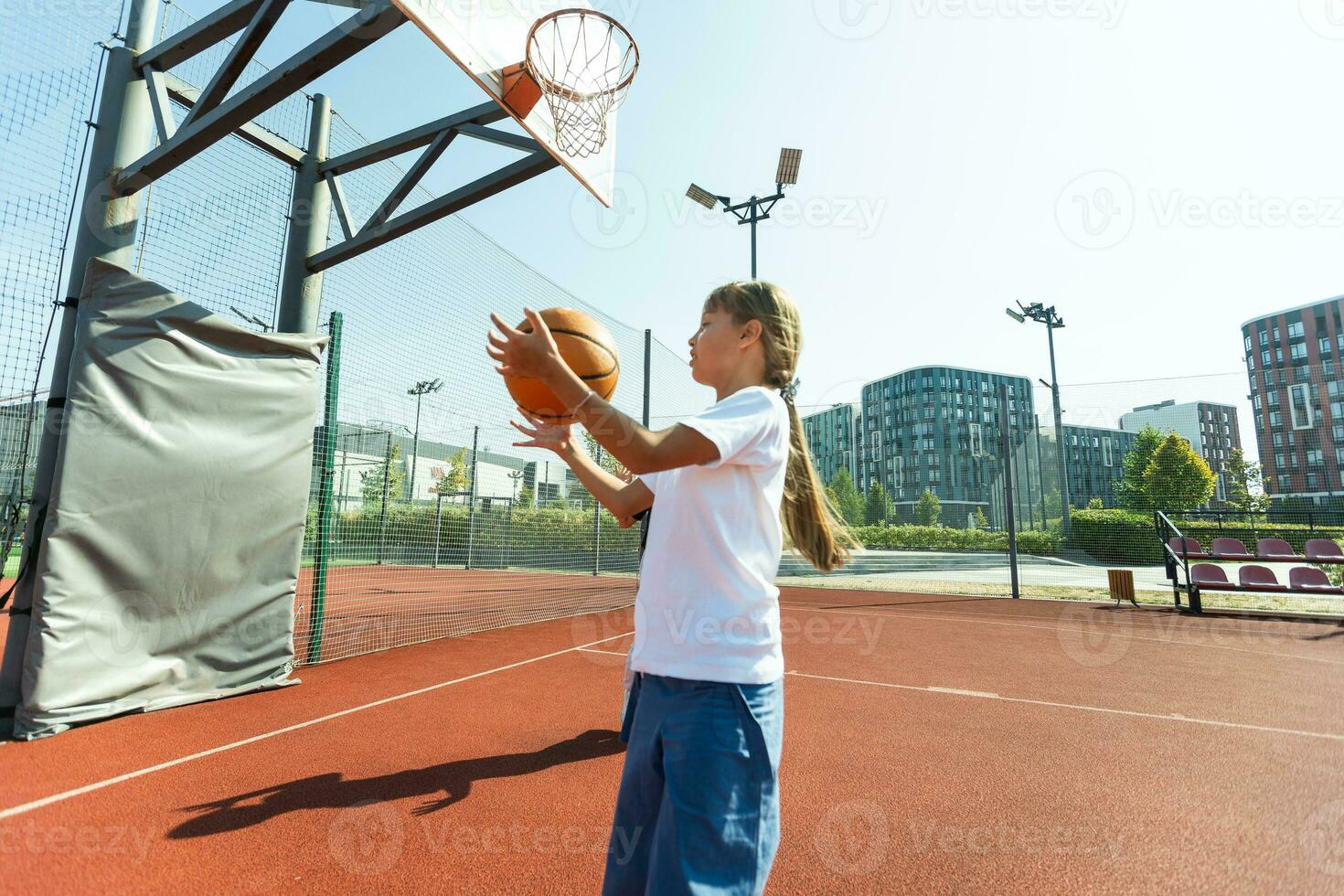 concepto de Deportes, aficiones y sano estilo de vida. joven atlético niña es formación a jugar baloncesto en moderno al aire libre baloncesto corte. contento mujer foto