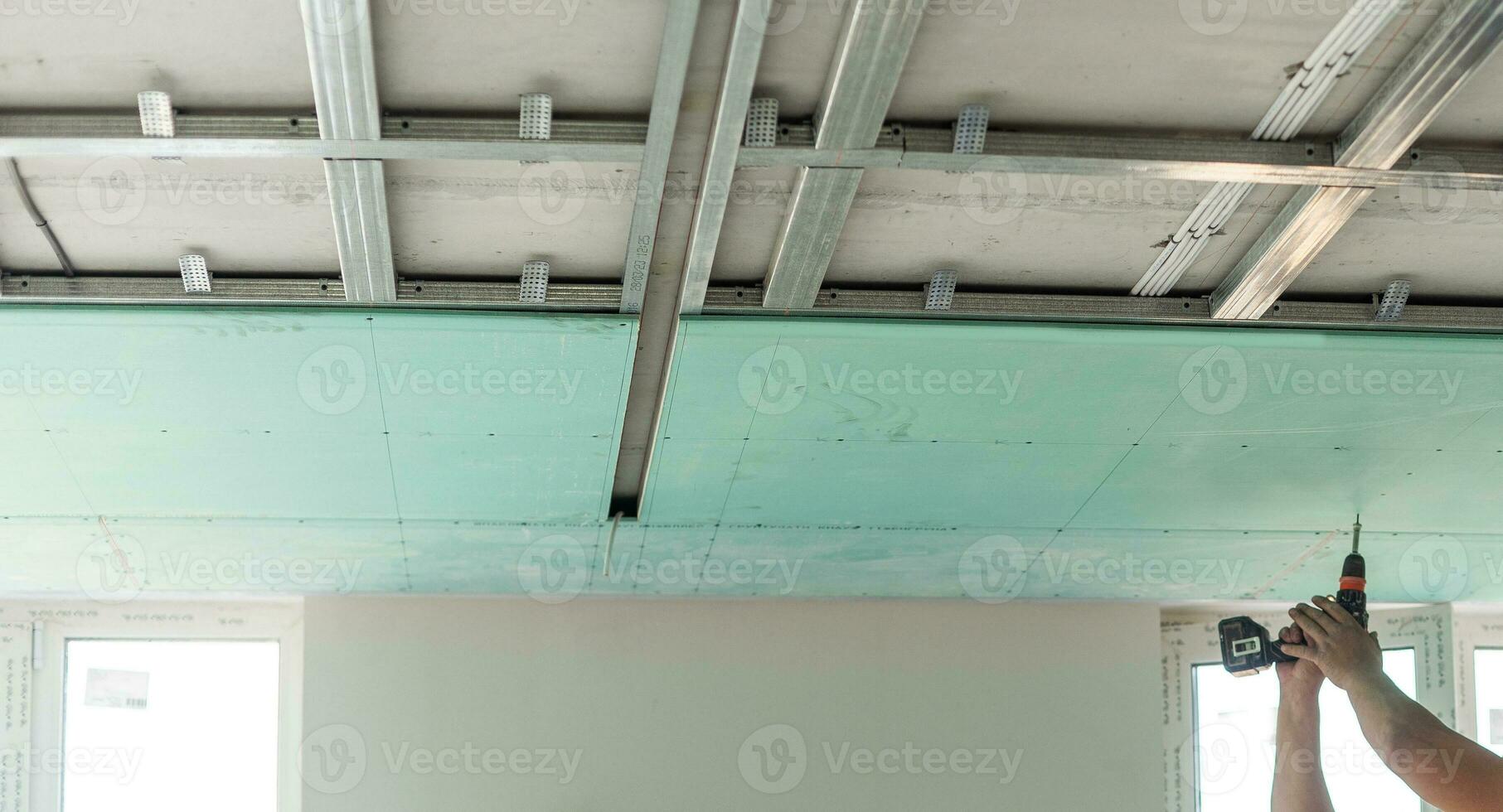 Drywall Installers. Men holding a gypsum board figured cut photo