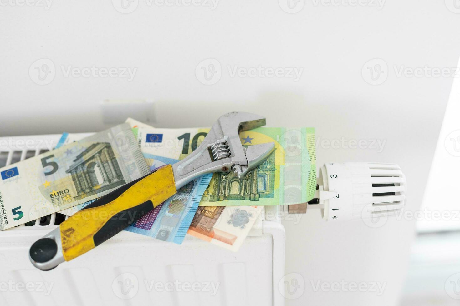 A stack of money on the background of the radiator. Expensive utilities. photo