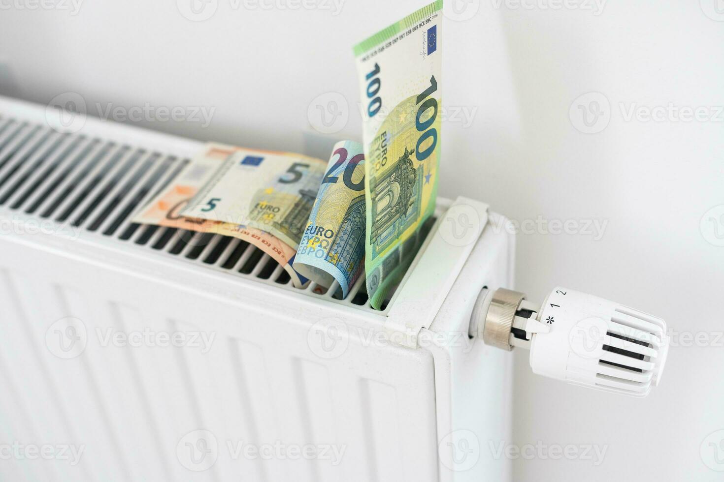 banknote lying on the radiator, the concept of rising energy prices and more expensive heating photo