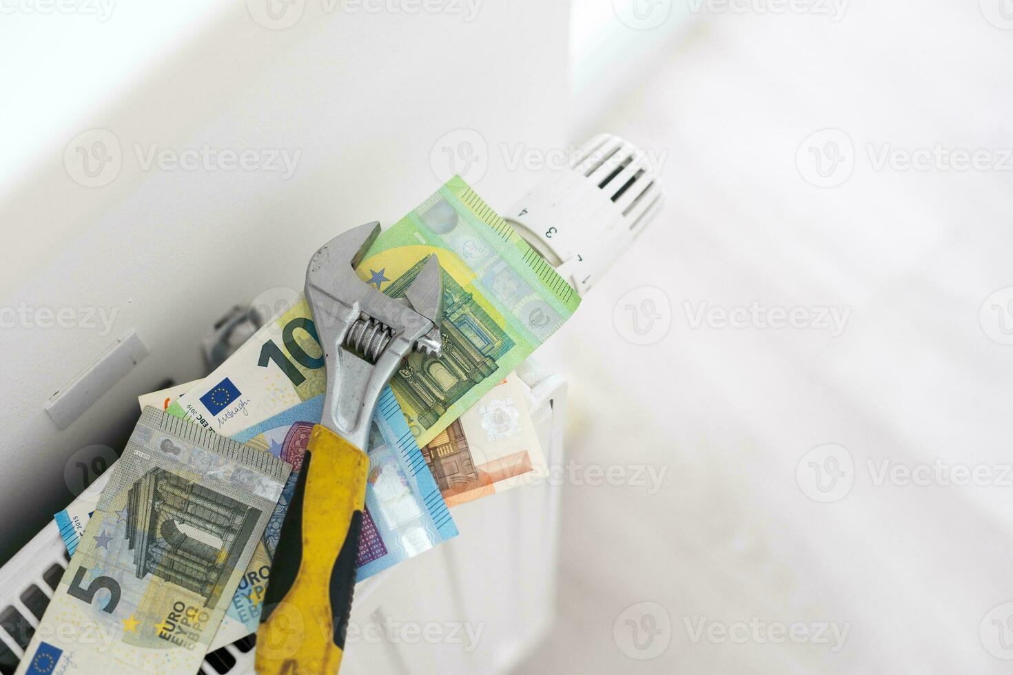 A stack of money on the background of the radiator. Expensive utilities. photo