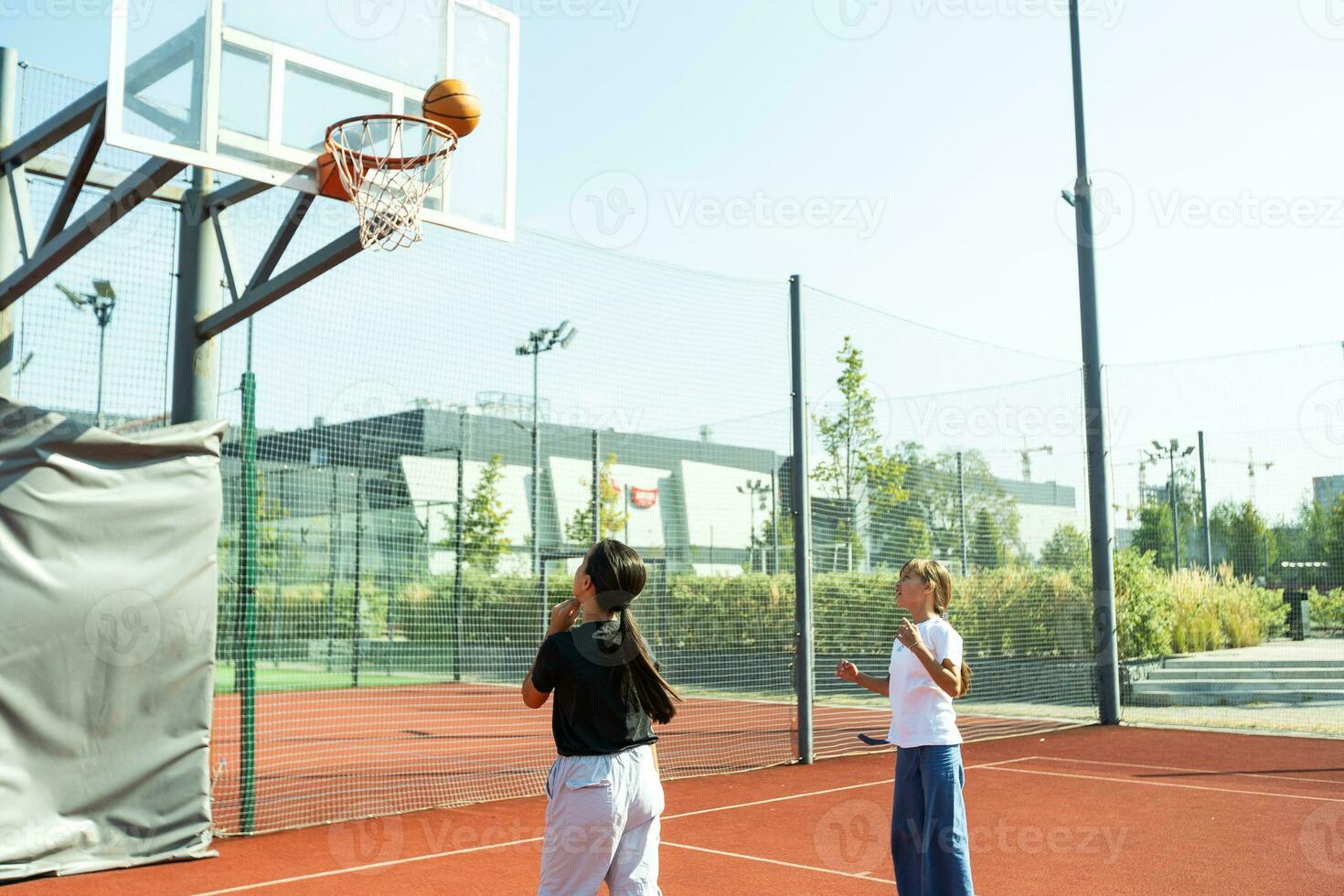 Children and sports. Teenage girl playing basketball on the playground. photo