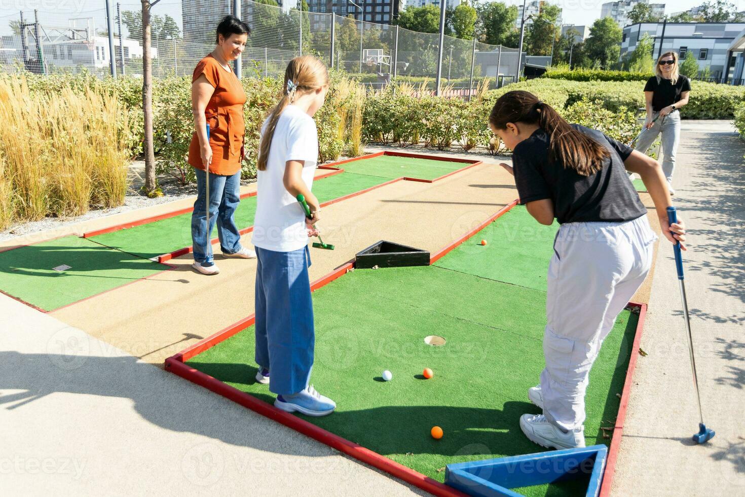 family playing mini golf on a cruise liner. Child having fun with active leisure on vacations. photo