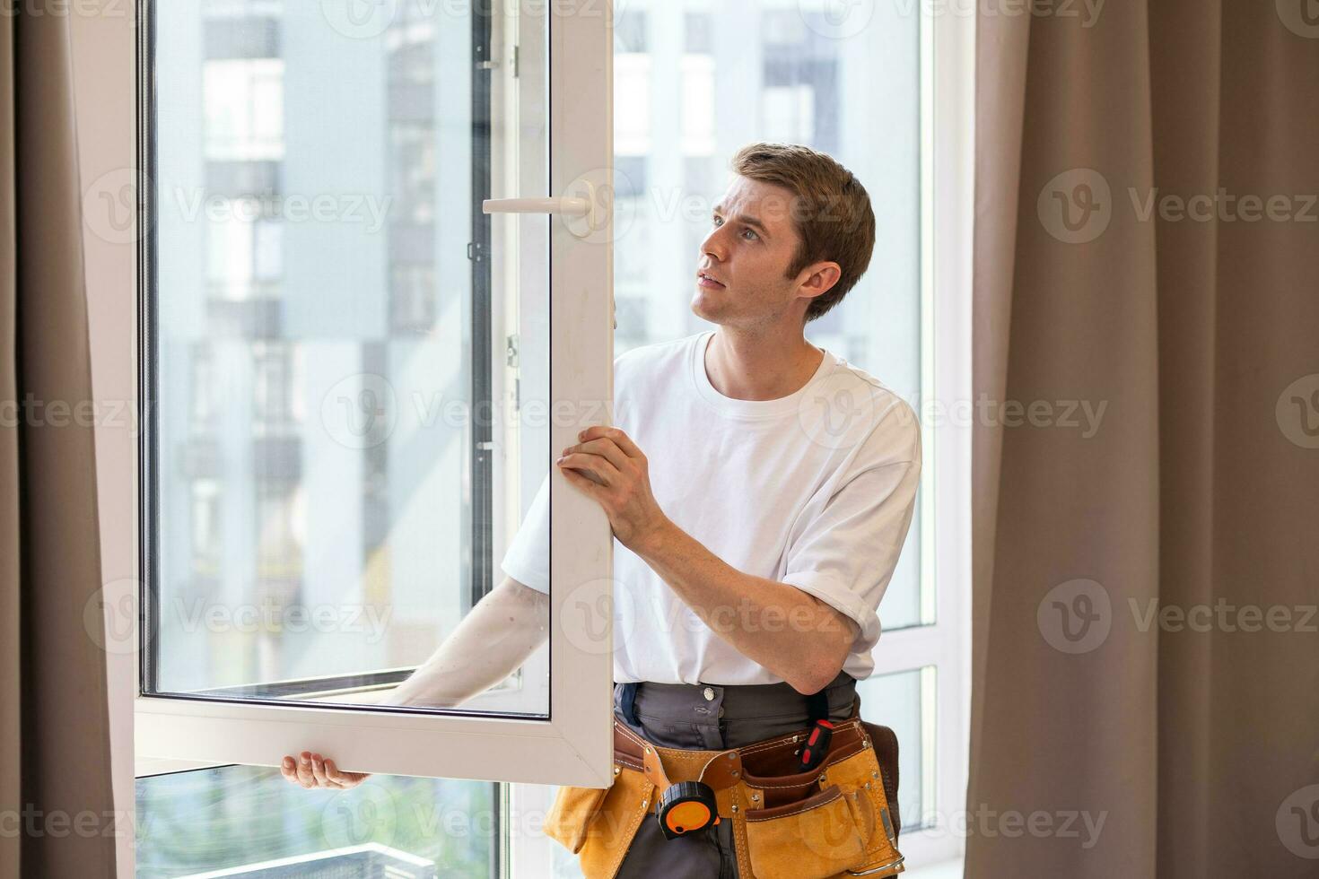Construction worker installing window in house. photo