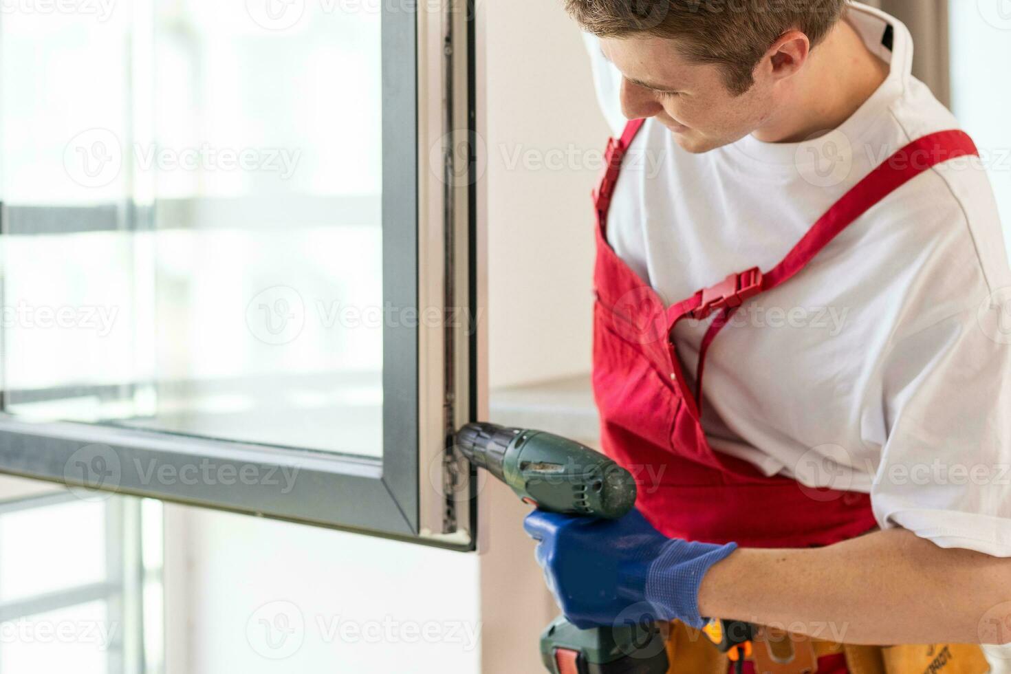 A repairman fixing windows in new apartment photo