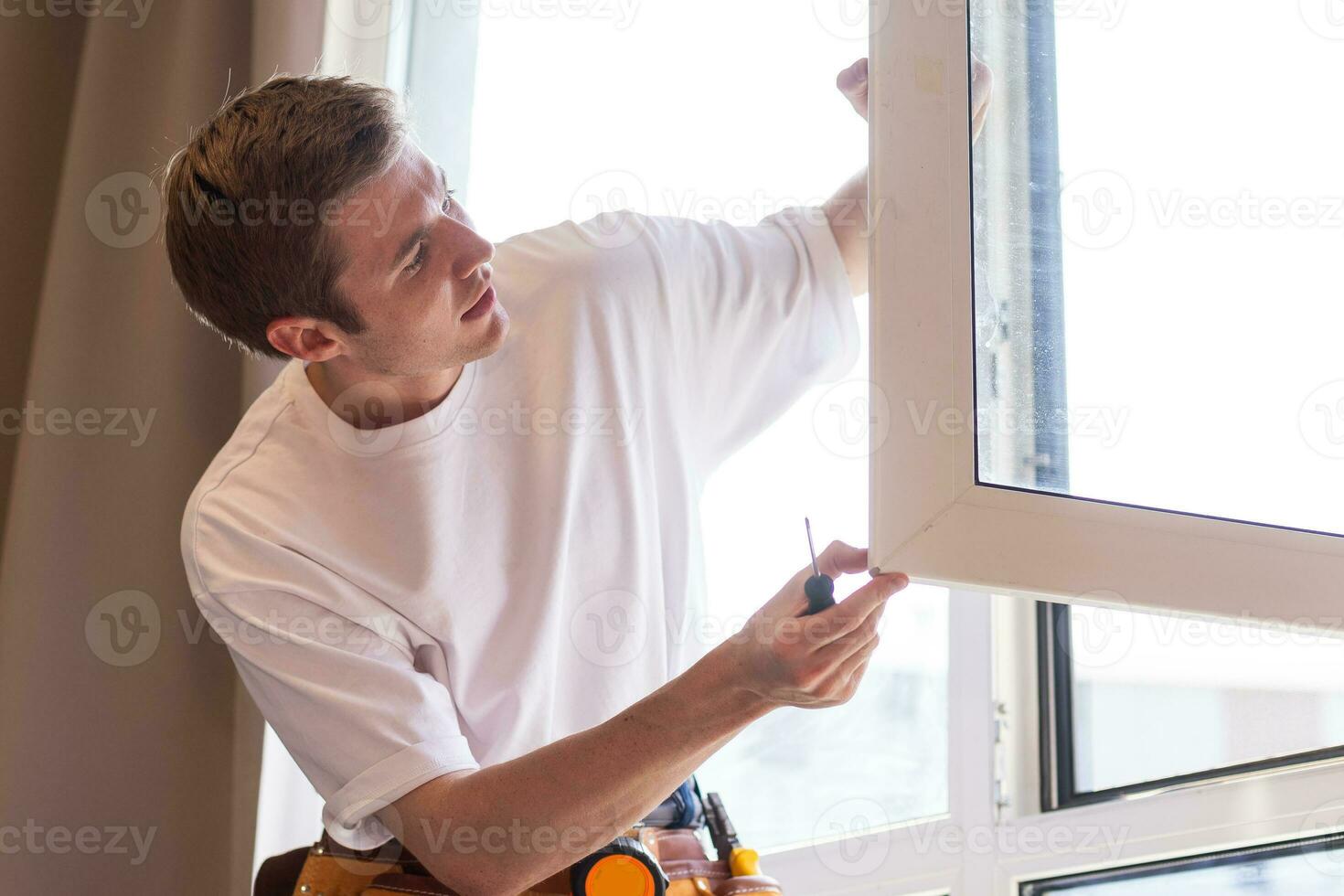 A repairman fixing windows in new apartment photo