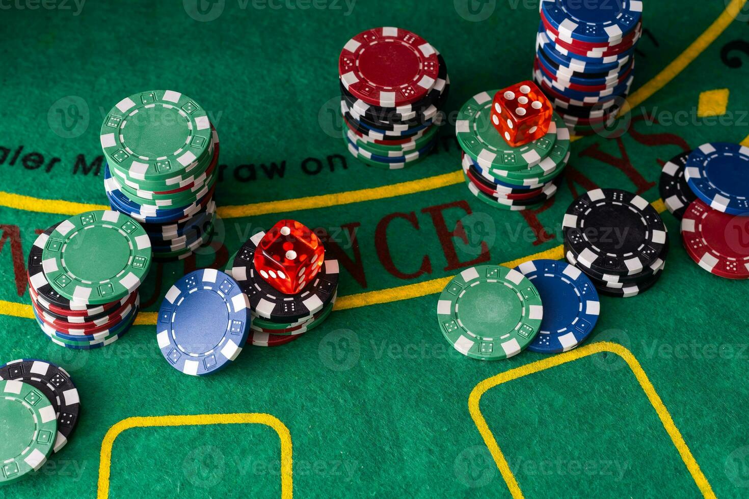 on the green poker table are playing cards, and lots of colored chips. Poker concept photo