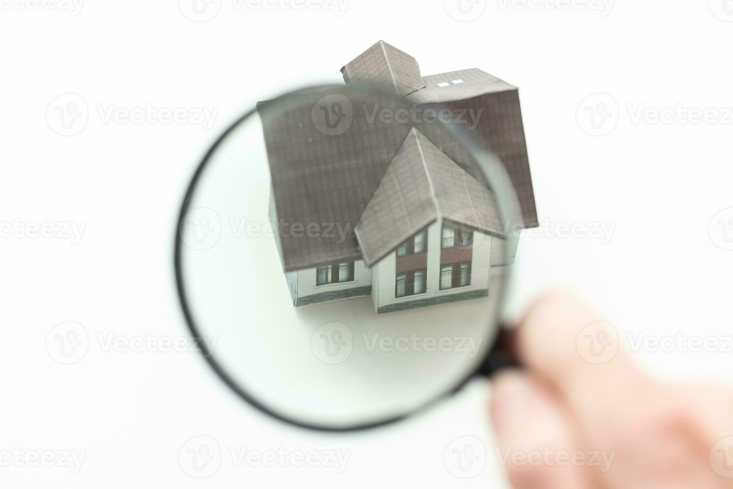 magnifying glass examining model home. Isolated on white. photo