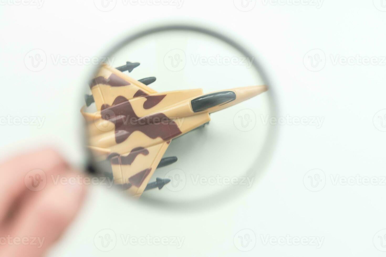 Review airlines company service and tickets price concept. Airplane model under magnifying glass on grey background. photo