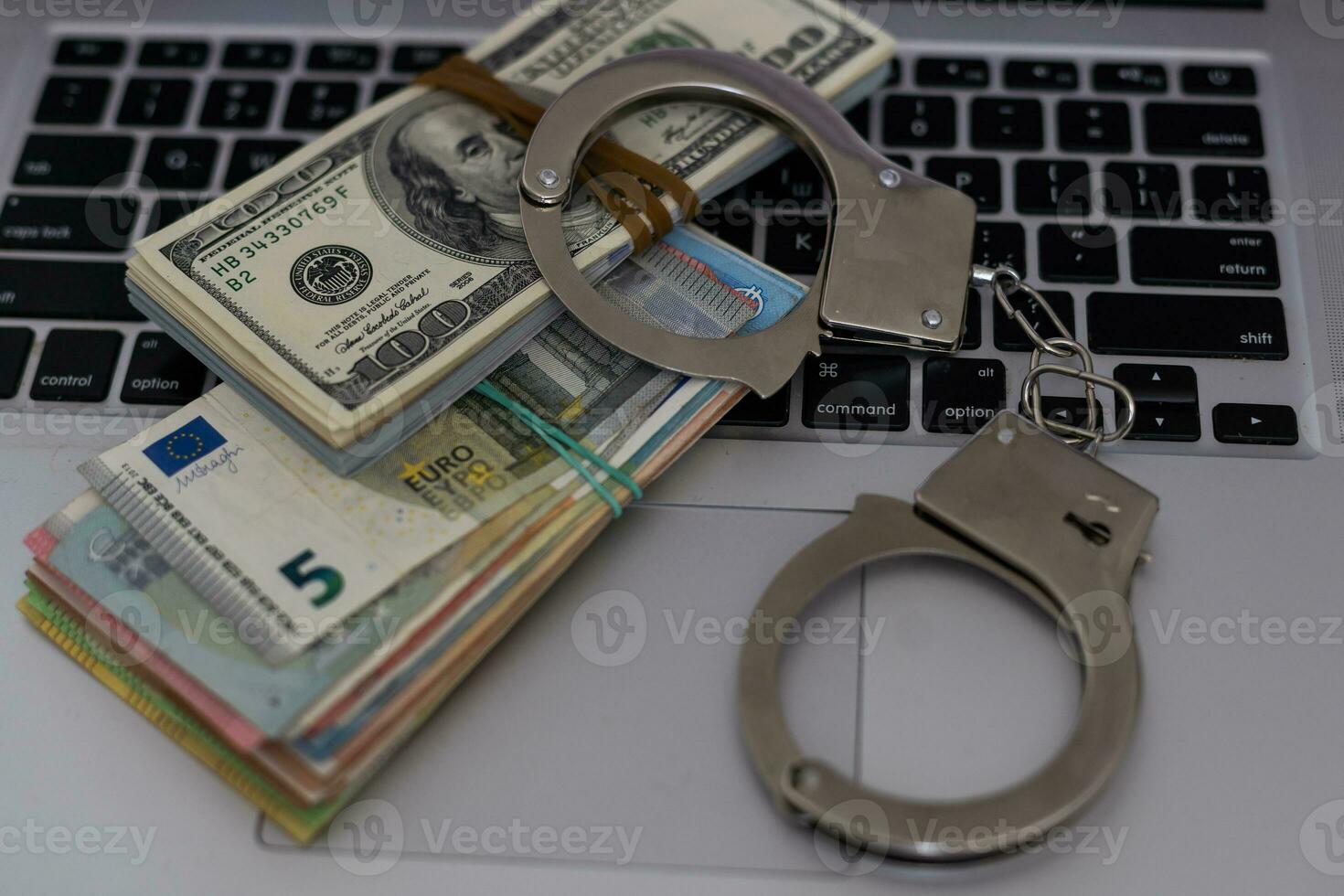 Police handcuffs lie on many dollar bills isolated on black background. Crime. justice and money. Concept of crime and corruption with handcuffs. photo
