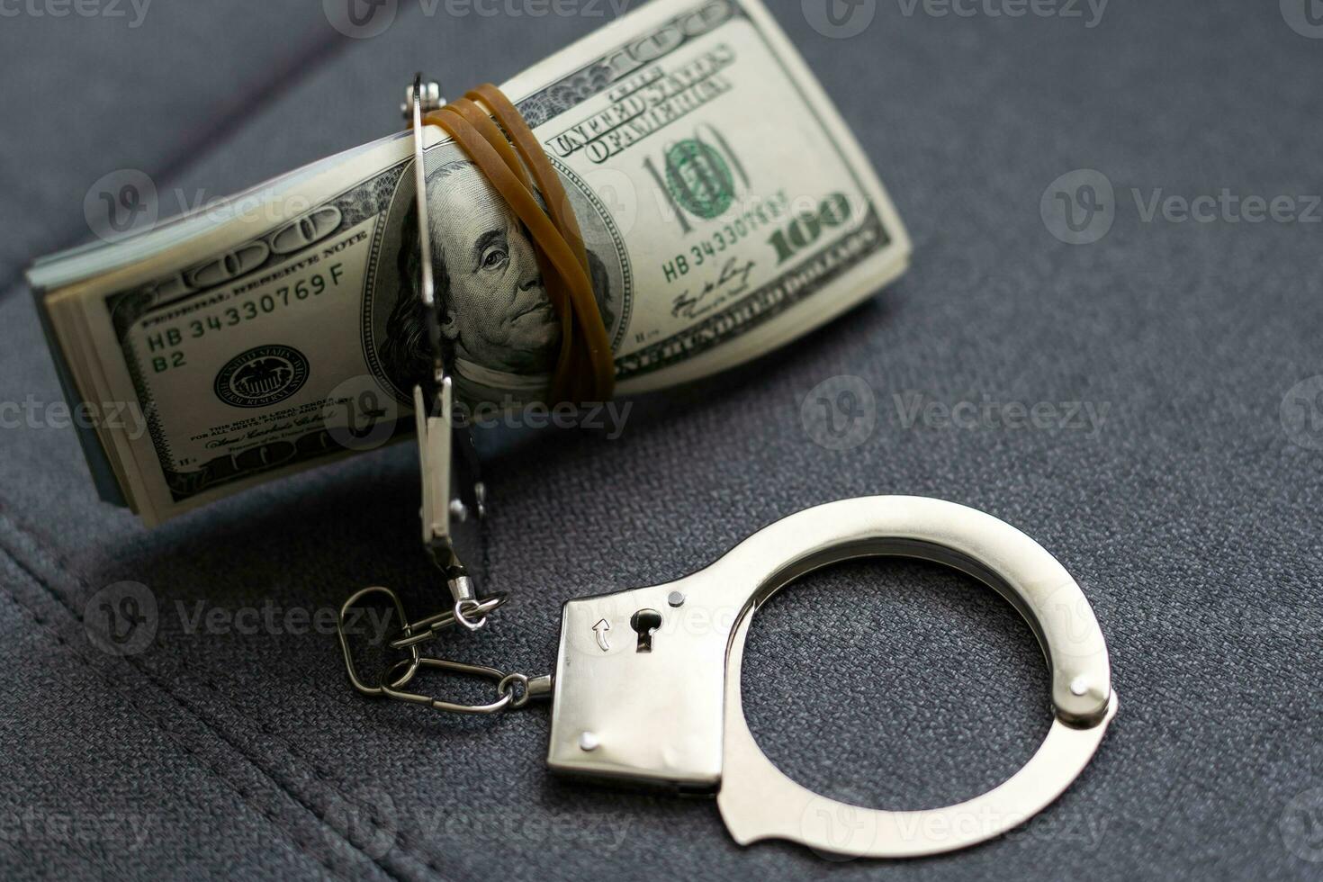Police handcuffs lie on a lot of dollar bills. The concept of illegal possession of money, illegal transactions with US dollars. Economic Crime photo