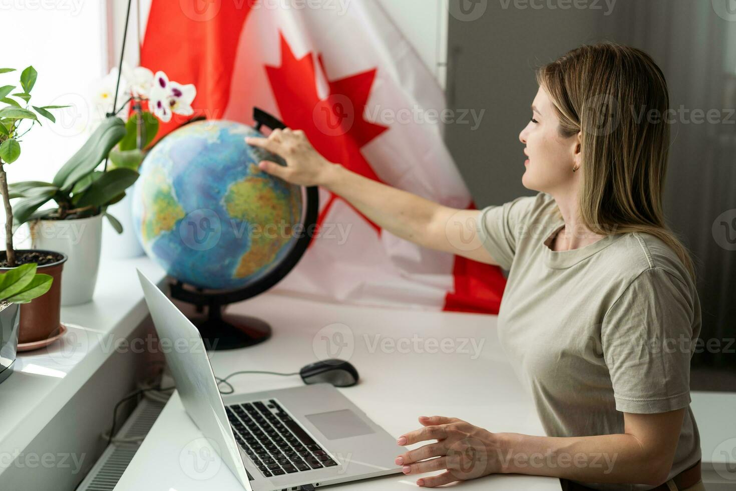 female student sitting with canadian flag and using laptop photo