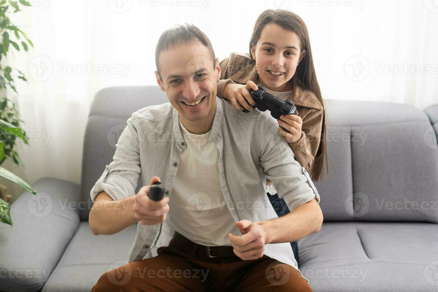 excited father and daughter playing video game at home. photo